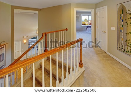Upstairs hallway with staircase. Staircase with carpet steps, white railings with brown trim
