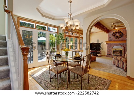 American house interior. Bright dining area with walkout patio in luxury house. DIning glass table with chairs
