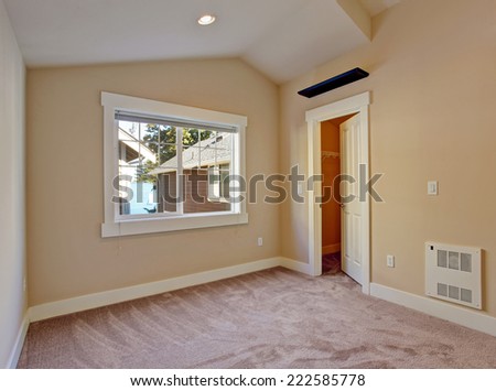 Empty bedroom in ivory and light brown tones with walk in closet