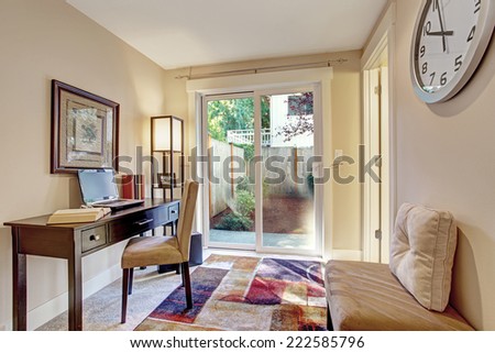 Light ivory room with office desk and exit to backyard area