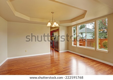 Bright empty room with window, ivory walls and new hardwood floor