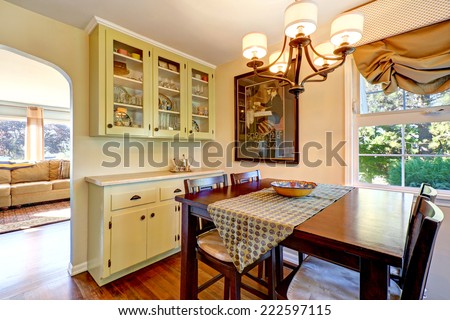 Dining area with wooden table set and old storage cabinets in old house
