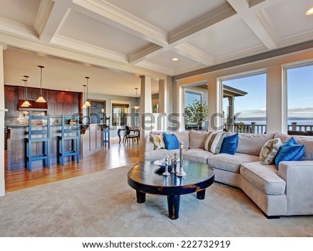 Luxury house with open floor plan. Cozy living room in light tones with comfortable sofa and coffee table