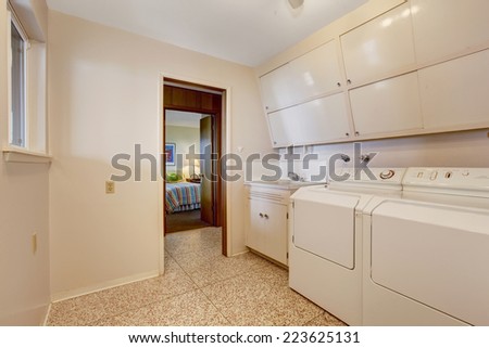 Laundry with built in cabinets, old washer and dryer