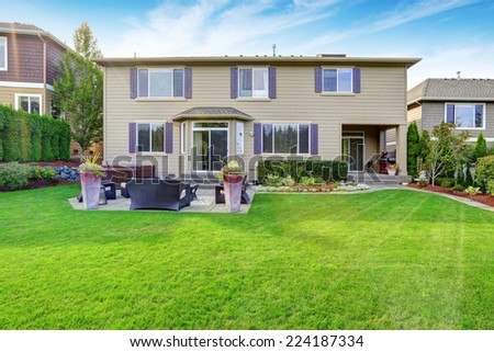 Luxury house exterior with impressive backyard landscape design and patio area