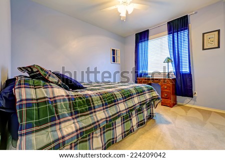 Simple bedroom with office area. Light lavender wall, blue curtains and green tone bedding