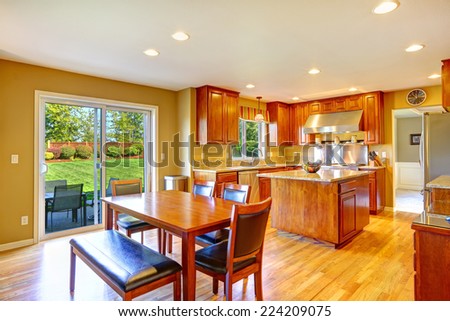 Luxury kitchen room with island, dining table set and exit to backyard patio area