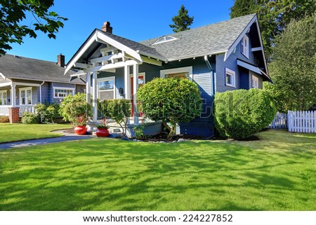 Simple house exterior with tile roof. Entrance porch with front yard landscape