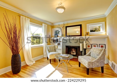 Family room with cozy sitting area. Two chairs and glass top coffee table. Room decorated with dry bushes