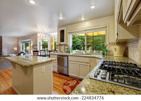 Kitchen with white storage combination and kitchen island. Cabinet with granite tops