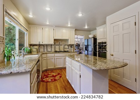Kitchen room with white storage combination, granite tops and kitchen island