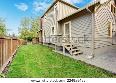 House with small deck and fenced backyard