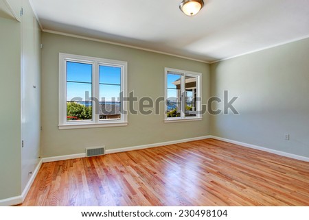 Empty master bedroom interior with windows and hardwood floor