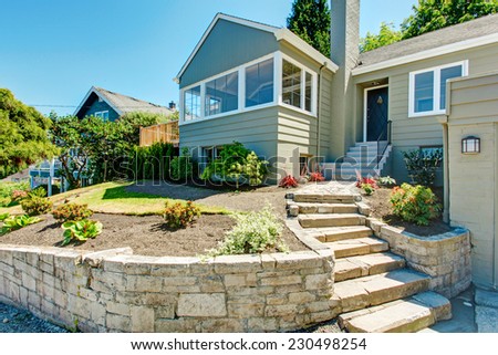House exterior in clapboard siding and  front yard landscape, Stairs with stone trim