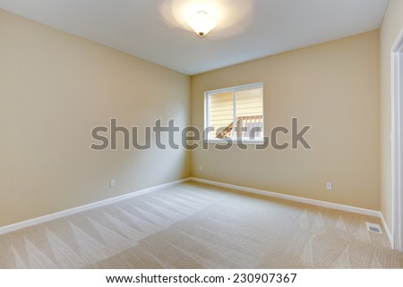 Bright empty bedroom in light ivory tone with carpet floor and small window