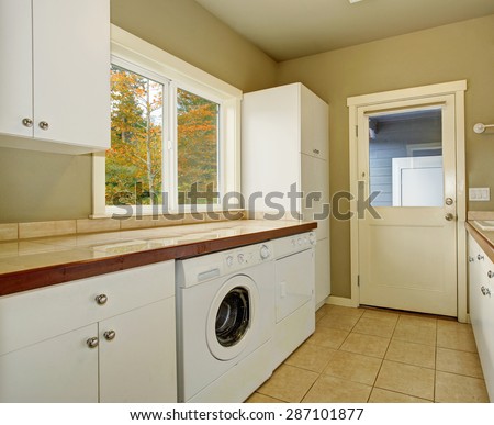 Laundry room with cabinets, tile counters, washer, and dryer.