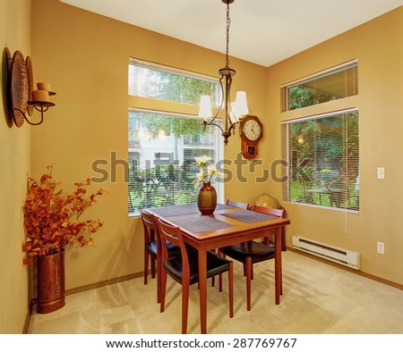 Warm dining room with carpet windows, table and chairs.