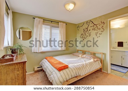 Bright bedroom with green walls and striped bedding.