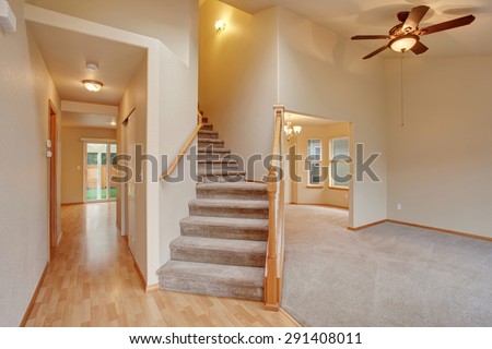 Traditional entry way with stairs and carpet.