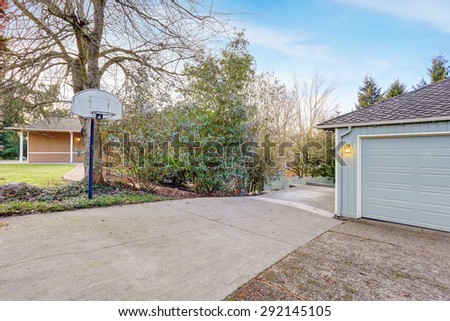 small blue house with garage, walkway, and grass.