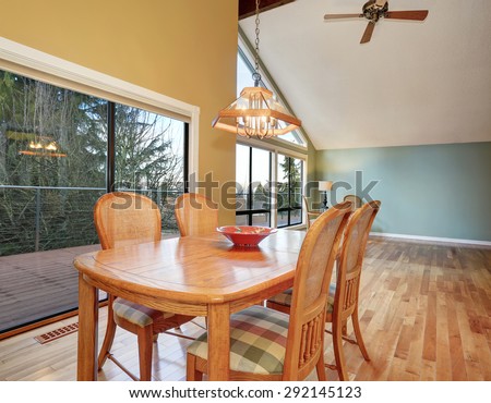 Large dinning area with hardwood floor and big windows.