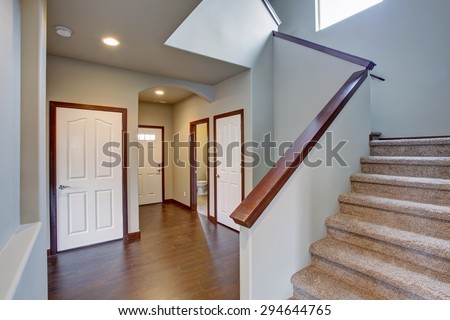 Elegant hallway with stairs, hardwood floor, and lovely dark wood trim.