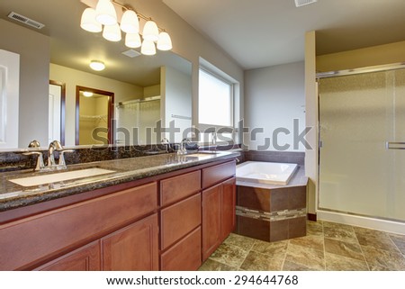 Large elegant master bathroom with tile floor, marble counters, including an excellent tub and shower.