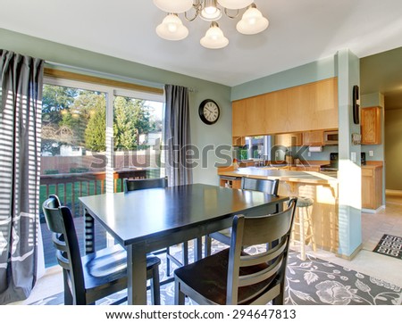 Well put together dinning room with sliding glass door, window, and modern decor rug.