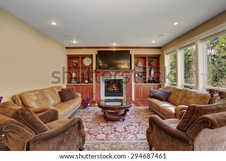 Decorative living room with leather sofas, hardwood floor, and a rug.