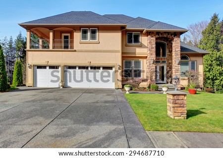 Luxury home with large grass yard and garage.