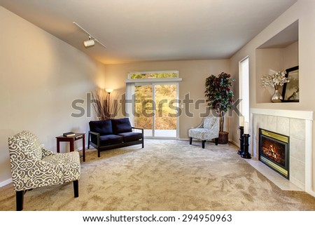 Present day living room with fireplace, carpet, and sliding glass door.