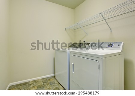 Small laundry room with stone tile floor and full washer dryer set.