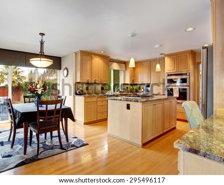 State of the art kitchen with hardwood floor, glossy counters, and stainless steel fridge.