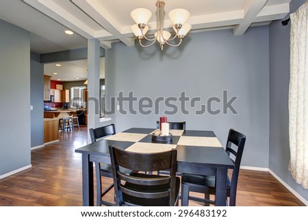 Simplistic dinning room with gray walls, and black table chair set.
