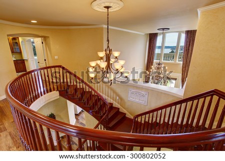 Elegant luxury double staircase with deep stained wood railing.