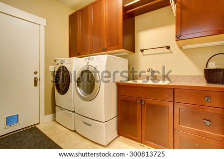 Modern laundry room with tile floor, also washer and dryer.