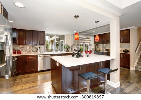 Large kitchen with white counter tops, and a big island.
