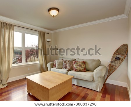 Simple room with hardwood floor, and tan sofa.