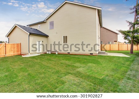 Luxury back yard with unfurnished patio, and fence.