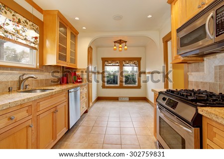 Traditional kitchen with stainless steel dish washer and tile floor.