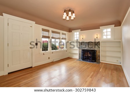 Cozy living room with rose and white interior paint, also including fireplace.