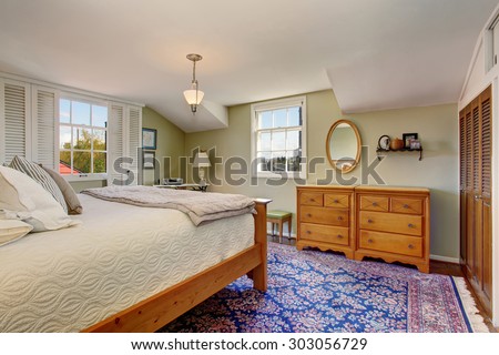 Vintage themed bedroom with blue decorative rug and white bedding.