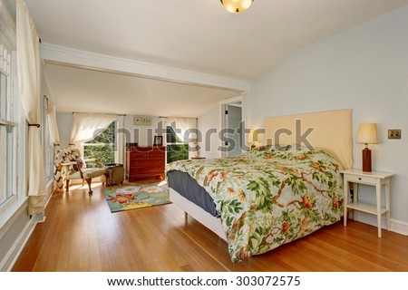 Large spring themed bedroom with tree decor bedding, and light blue walls.
