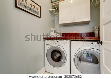 Small laundry room with tile floor, door, and washer dryer set.