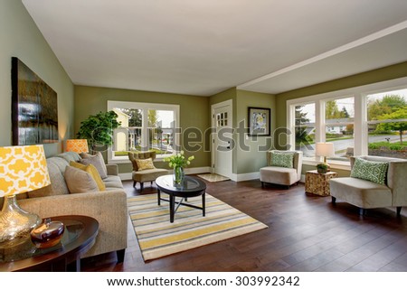 Well decorated living room with hardwood floor, and green yellow theme.