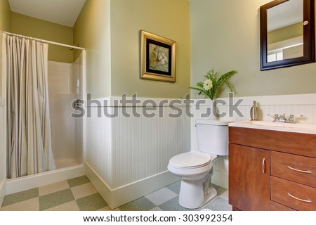 Bathroom with checkered tile floor, striped shower curtain, and green interior paint.