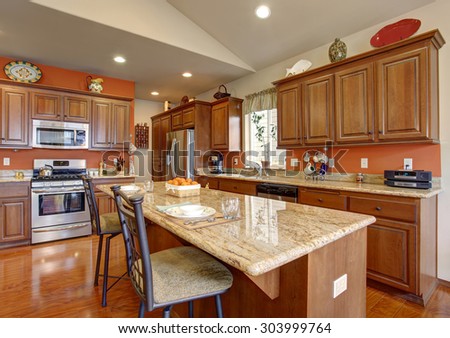 American traditional kitchen with glossy hardwood floor, and an island.