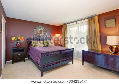 Elegant bedroom interior with purple and red decor tones.