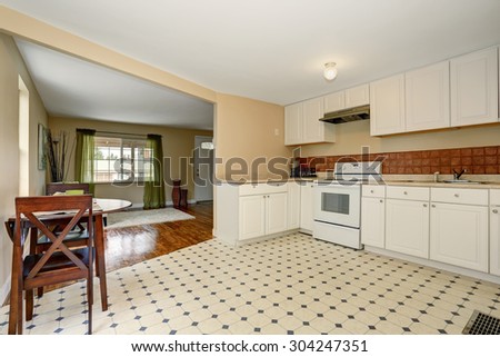 Very simple kitchen with tile floor, and tan walls.