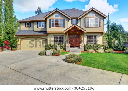 Luxurious home with well kept lawn, and green exterior paint.
